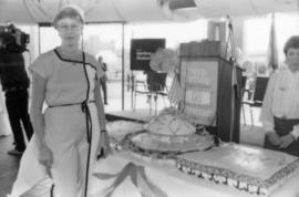 Woman posing beside birthday cake