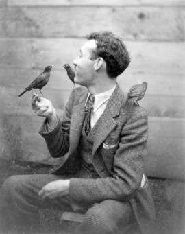 [Bob Bouchette feeding robins at Charles E. Jones' Birds' Paradise]