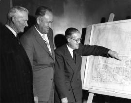 P.N.E. President J.F. Brown and others looking at proposed coliseum on map of P.N.E. grounds