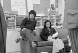 Two young people in an office or waiting area