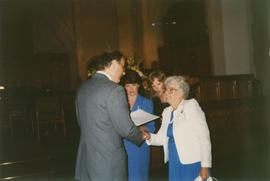 Mrs. Gertrude (Fitch) Roper in white jacket shaking hands with Mayor Michael Harcourt