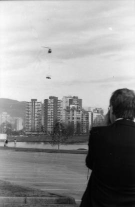 Man photographing helicopter from parking lot