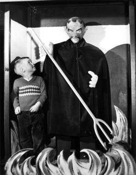 Young boy with model of a devil