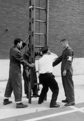 [Vancouver Fire Department staff member demonstrating hoisting of ladder]