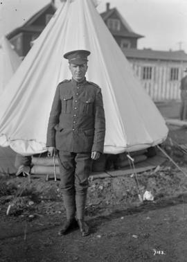 [Soldier in front of a tent]