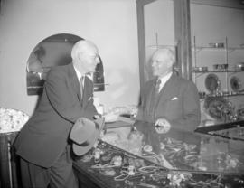 [Man handing a cheque to another man at a jewellery store]