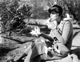 [Doris Milligan feeding robins at Charles E. Jones' Birds' Paradise]