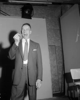 [Portrait of a man posing with a cigarette on a film stage]