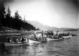 Group of adults and children, wearing swimwear, in four rowboats on lake at Camp Fircom