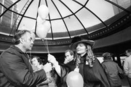 Woman in costume handing balloons to Don Bellamy