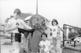 Troy Zwolinski, David LeBrun and Jasmine Gibbons clean graffiti off mailbox