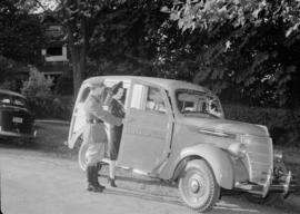 Women getting into a car from Glenairley Farm while a man in uniform holds the door