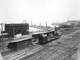 [Progress photograph of a construction and rail yard next to Pier "B/C"]