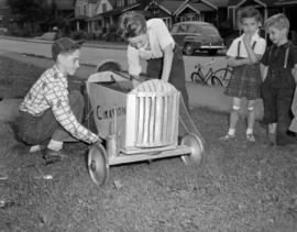 [Children playing with a go-cart]