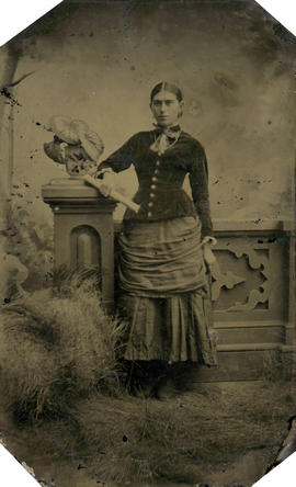 [Studio portrait of young woman holding rolled document]