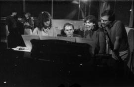 Group at piano in recording studio