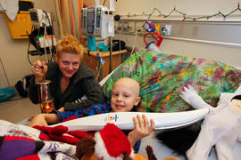 Day 52 Lyric Jarvis holds the torch while his mother Sarah cradles the flame Children's Hospital ...