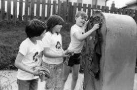 David LeBrun, Jasmine Gibbons and Troy Zwolinski clean graffiti off mailbox